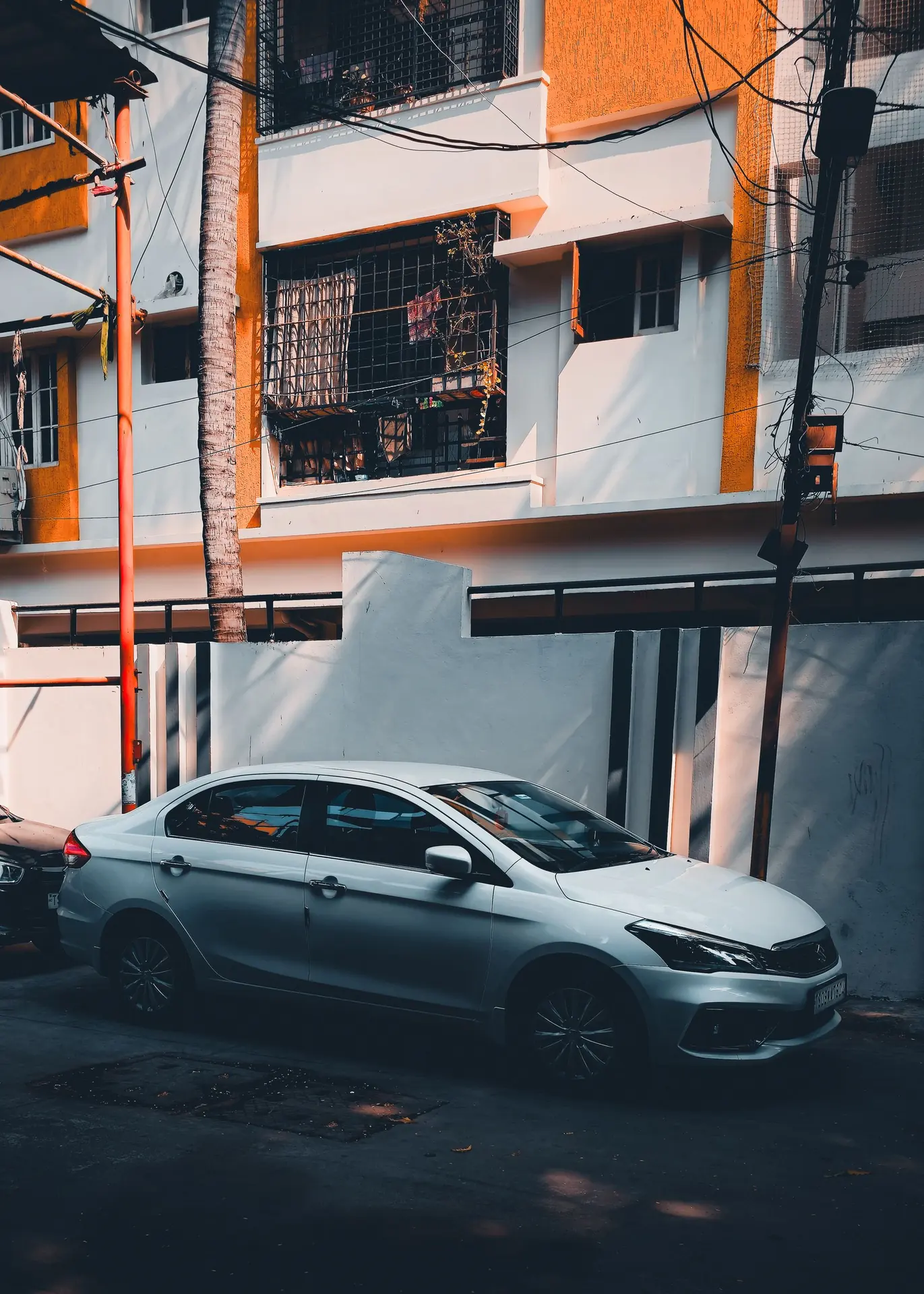 A clean sedan parked outside a Hyderabad apartment block.